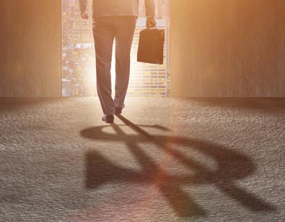 A man with a shadow of a dollar sign behind him