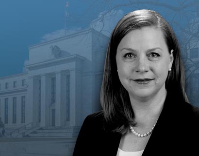 Michelle Bowman in front of a screen of the Federal Reserve Building