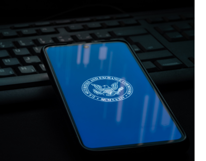 Phone with the SEC logo on it placed on a computer keyboard.